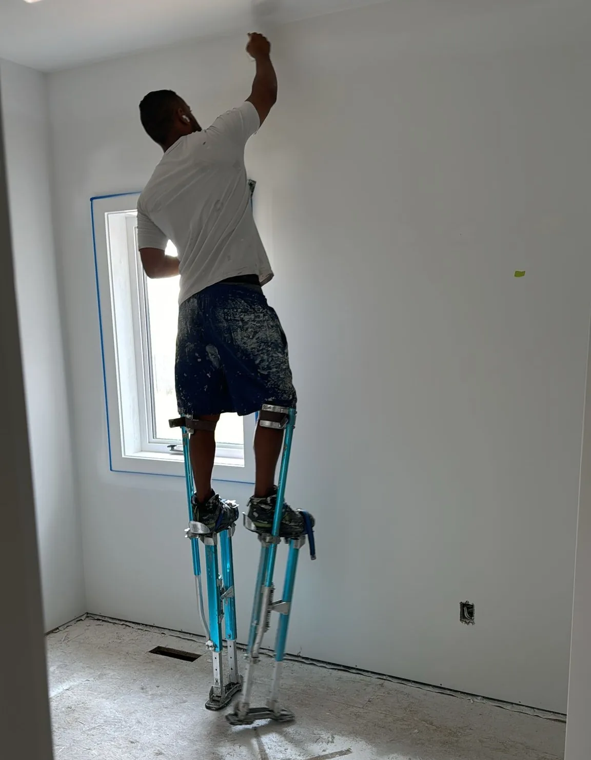 Painter working near an interior ceiling